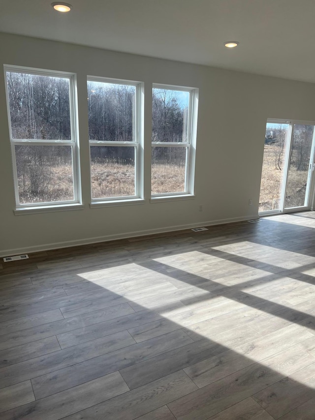 unfurnished room featuring recessed lighting, visible vents, baseboards, and wood finished floors