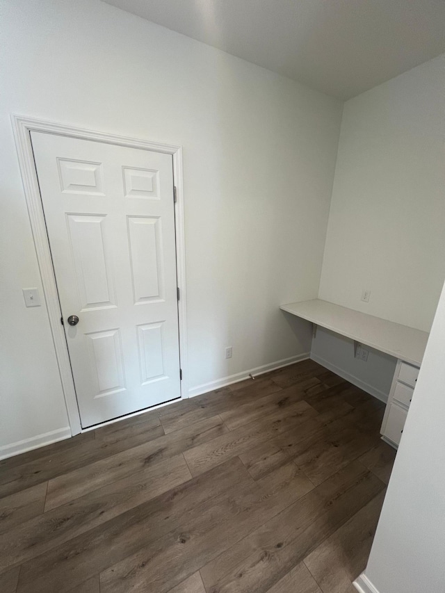 interior space featuring baseboards and wood finished floors