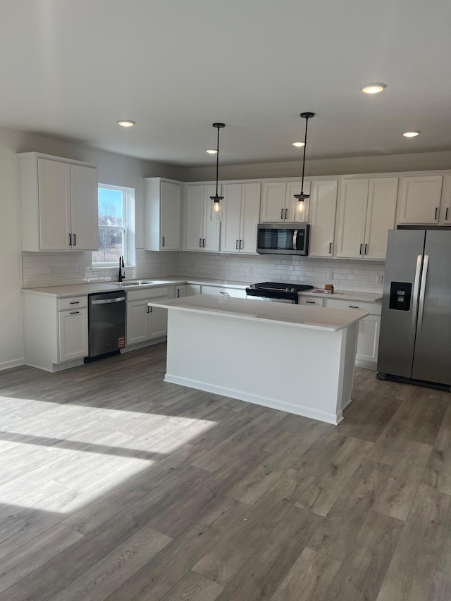 kitchen with light countertops, decorative backsplash, light wood-style flooring, stainless steel appliances, and white cabinetry