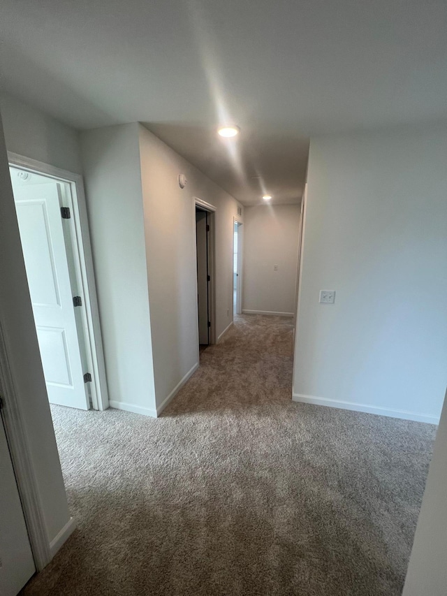 hall with baseboards and carpet