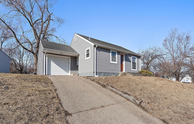 single story home with driveway and an attached garage