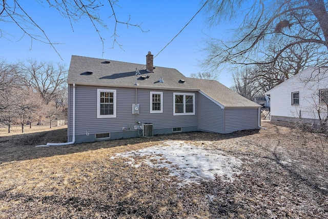 back of house with cooling unit and a chimney