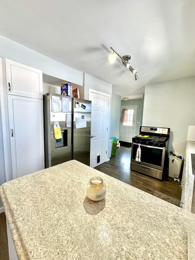 kitchen featuring light countertops, appliances with stainless steel finishes, dark wood-style flooring, and white cabinetry