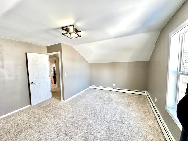 bonus room featuring a baseboard heating unit, carpet floors, vaulted ceiling, and baseboards