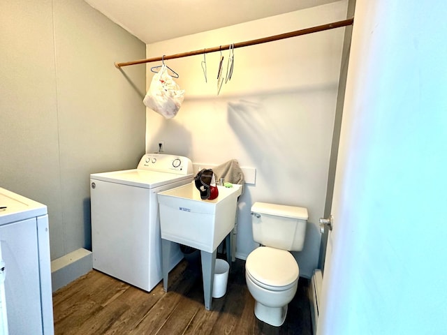 washroom featuring laundry area, washer / clothes dryer, baseboard heating, and wood finished floors