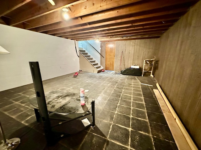 unfinished basement with wood walls and stairs