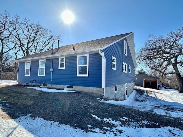 exterior space featuring roof with shingles and an outdoor structure