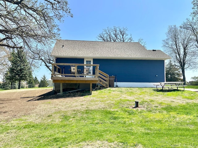 back of house with a yard, a deck, a shingled roof, and stairs