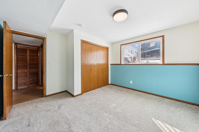 unfurnished bedroom with a closet, a textured ceiling, and carpet flooring