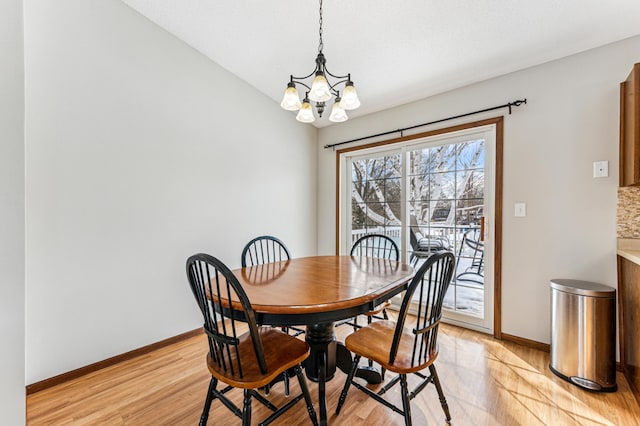 dining room with baseboards, light wood-style floors, and a chandelier