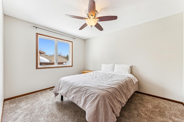 carpeted bedroom featuring ceiling fan, a textured ceiling, and baseboards