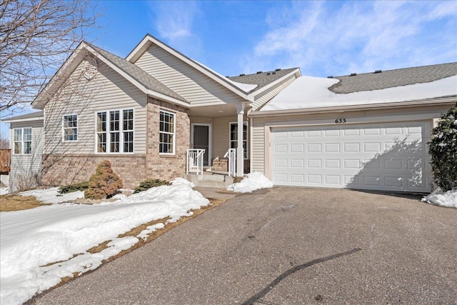 ranch-style home with brick siding, aphalt driveway, and a garage