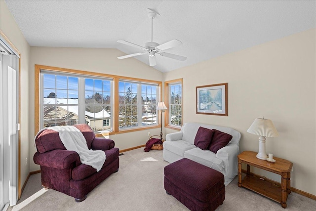 living area with carpet flooring, a ceiling fan, baseboards, and vaulted ceiling