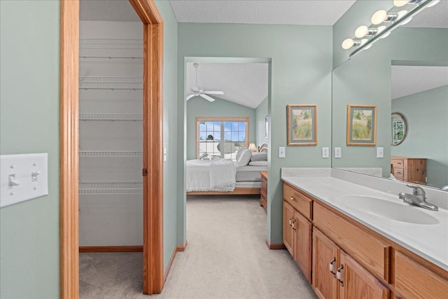 full bath with baseboards, vanity, vaulted ceiling, ensuite bathroom, and a textured ceiling