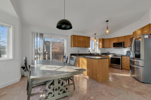 kitchen featuring a wealth of natural light, lofted ceiling, dark countertops, and appliances with stainless steel finishes