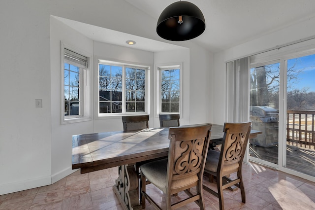 dining area with vaulted ceiling, baseboards, and a wealth of natural light