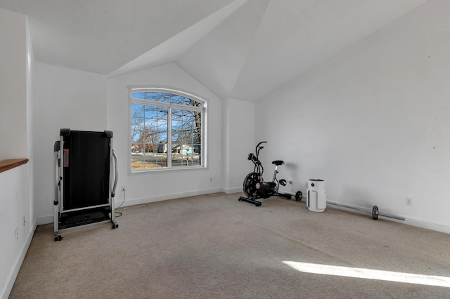 exercise room with vaulted ceiling, carpet, and baseboards