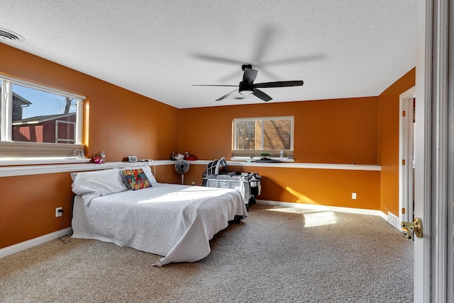 bedroom featuring visible vents, carpet floors, a textured ceiling, and baseboards