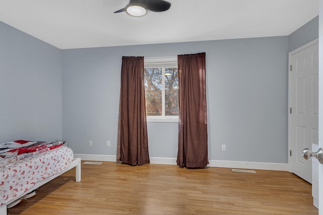 bedroom with visible vents, light wood-style floors, and baseboards