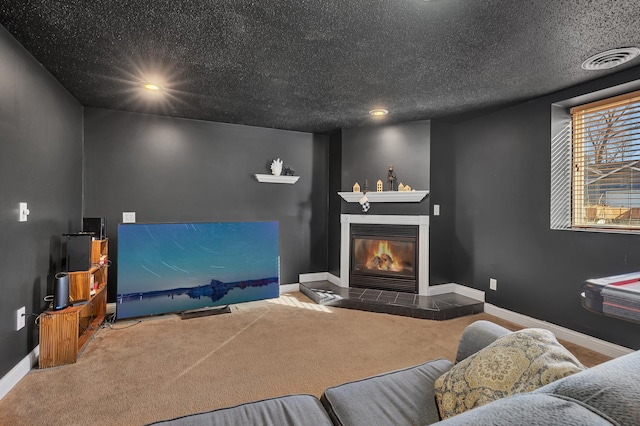 living room with a glass covered fireplace, a textured ceiling, baseboards, and carpet floors