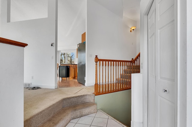 stairs featuring visible vents, carpet floors, baseboards, and tile patterned flooring