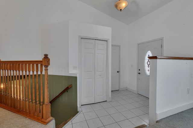 foyer featuring light tile patterned floors and lofted ceiling