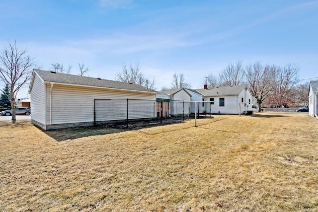 rear view of house with a yard and fence