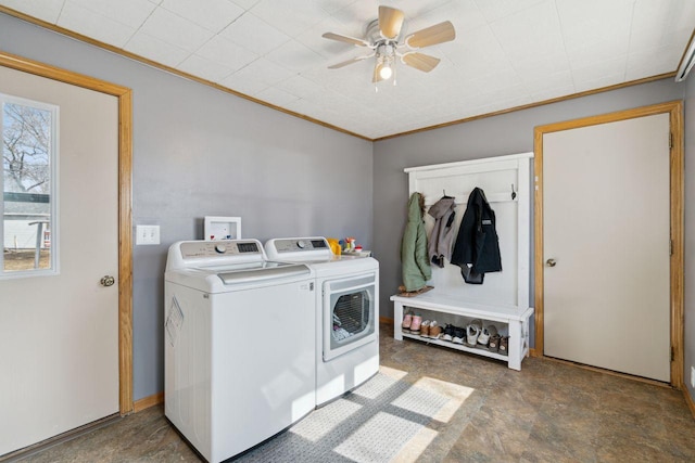 washroom with ornamental molding, a ceiling fan, washer and dryer, stone finish flooring, and laundry area