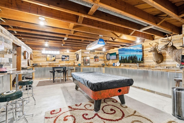 game room featuring unfinished concrete flooring, a dry bar, billiards, and wood walls