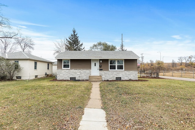 view of front of property with a front lawn, stone siding, and roof with shingles