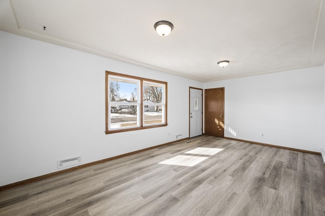 unfurnished room featuring visible vents, baseboards, and light wood finished floors