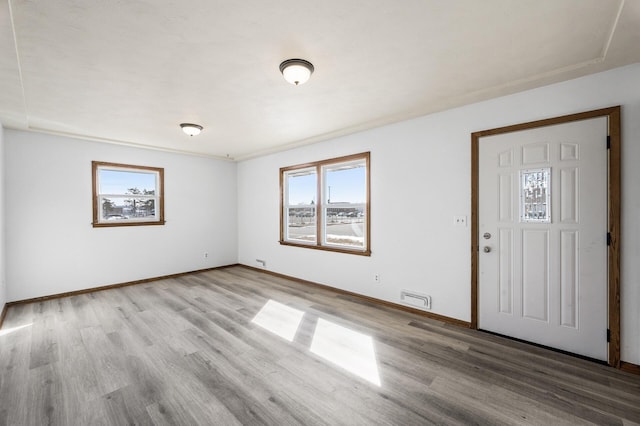 foyer entrance with baseboards, visible vents, and light wood-type flooring