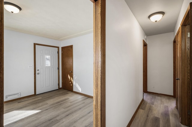 entrance foyer with visible vents, baseboards, and wood finished floors