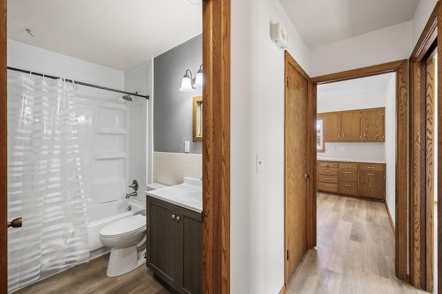 bathroom with vanity, shower / bathtub combination with curtain, toilet, and wood finished floors