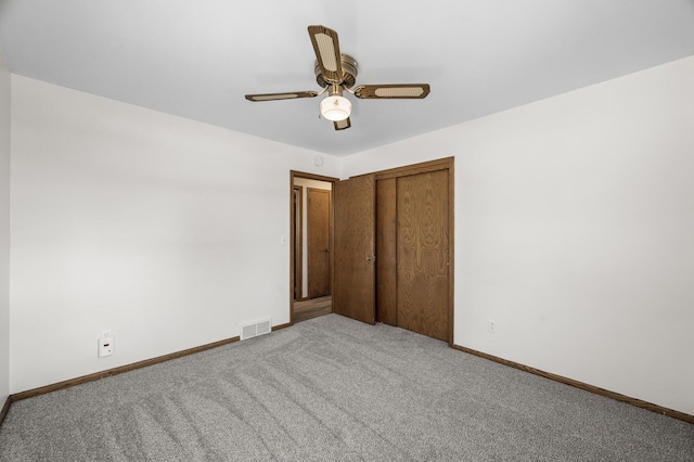 unfurnished bedroom with carpet, visible vents, baseboards, ceiling fan, and a closet