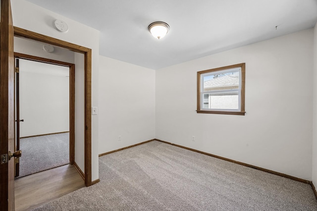 empty room with light colored carpet and baseboards