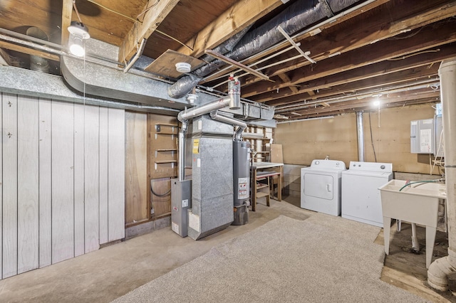 unfinished below grade area with gas water heater, heating unit, a sink, and washer and clothes dryer