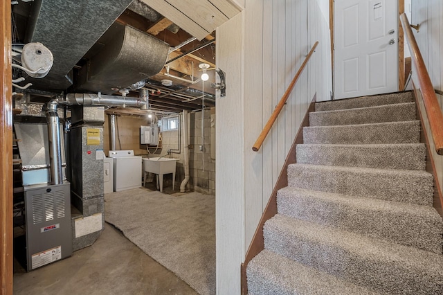 basement with stairs, electric panel, a sink, and washing machine and clothes dryer