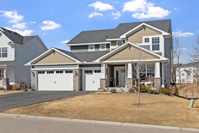 craftsman house with aphalt driveway, a porch, roof with shingles, stone siding, and an attached garage