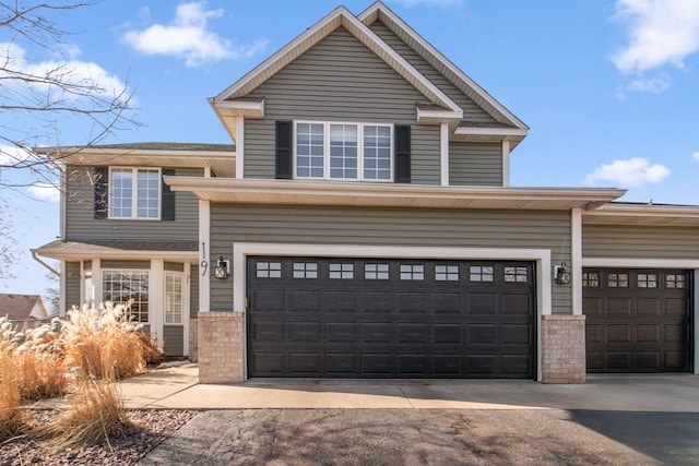 view of front facade featuring brick siding, aphalt driveway, and a garage