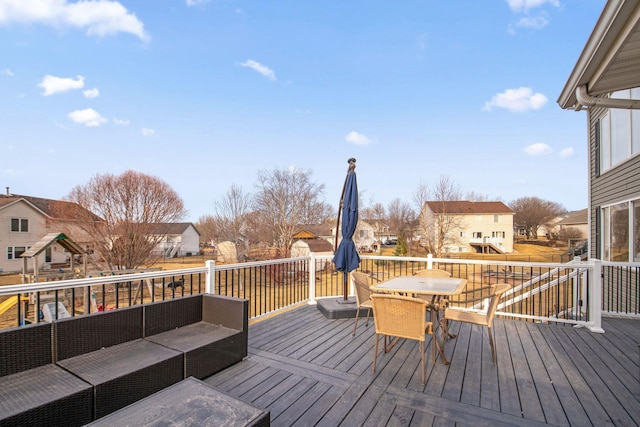 wooden deck with outdoor dining space, a residential view, and an outdoor hangout area