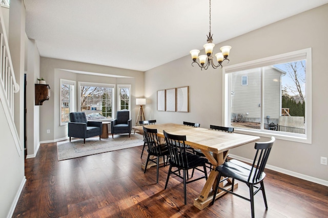 dining area featuring a chandelier, baseboards, and wood finished floors