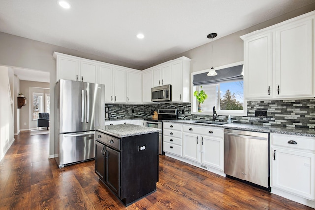 kitchen featuring a sink, decorative backsplash, white cabinets, and stainless steel appliances