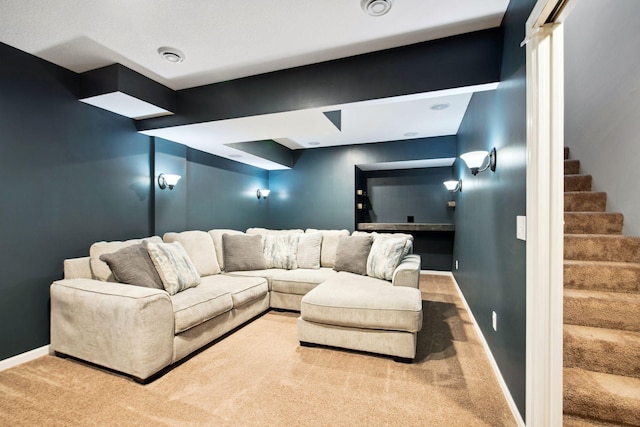 carpeted living area featuring stairway and baseboards