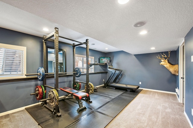 exercise area featuring carpet, recessed lighting, baseboards, and a textured ceiling