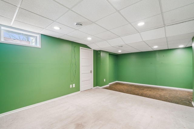 basement featuring a drop ceiling, recessed lighting, carpet, and baseboards