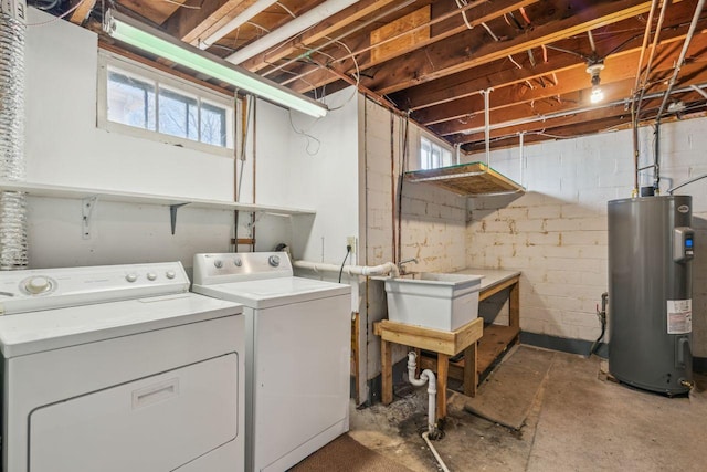 washroom featuring a sink, electric water heater, laundry area, and washer and clothes dryer