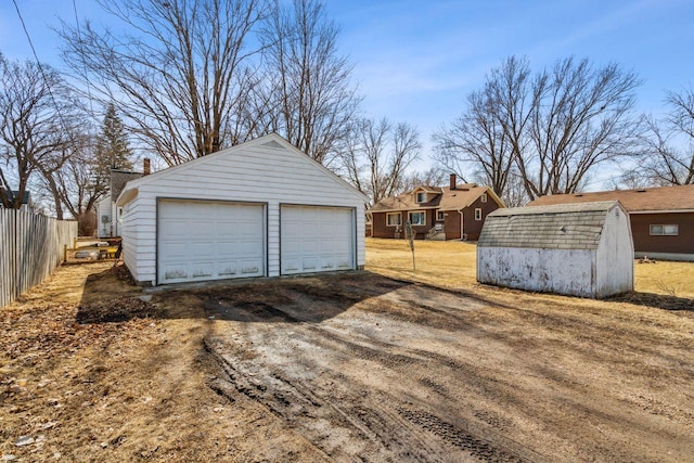 detached garage featuring fence