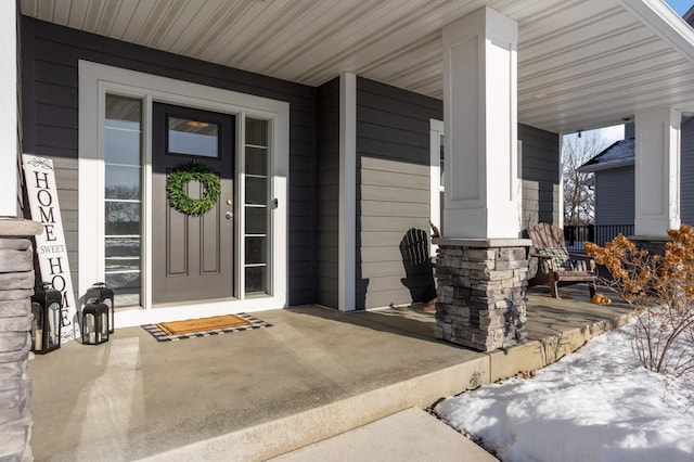 view of exterior entry featuring covered porch