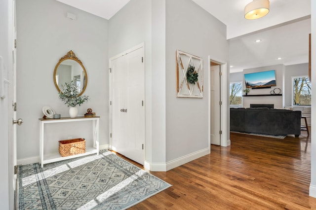 entrance foyer featuring recessed lighting, a fireplace, wood finished floors, and baseboards